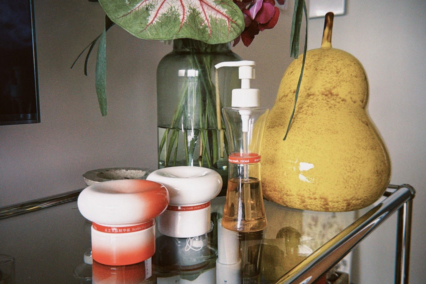 Herbeast skincare jars and a cleanser bottle on a shelf