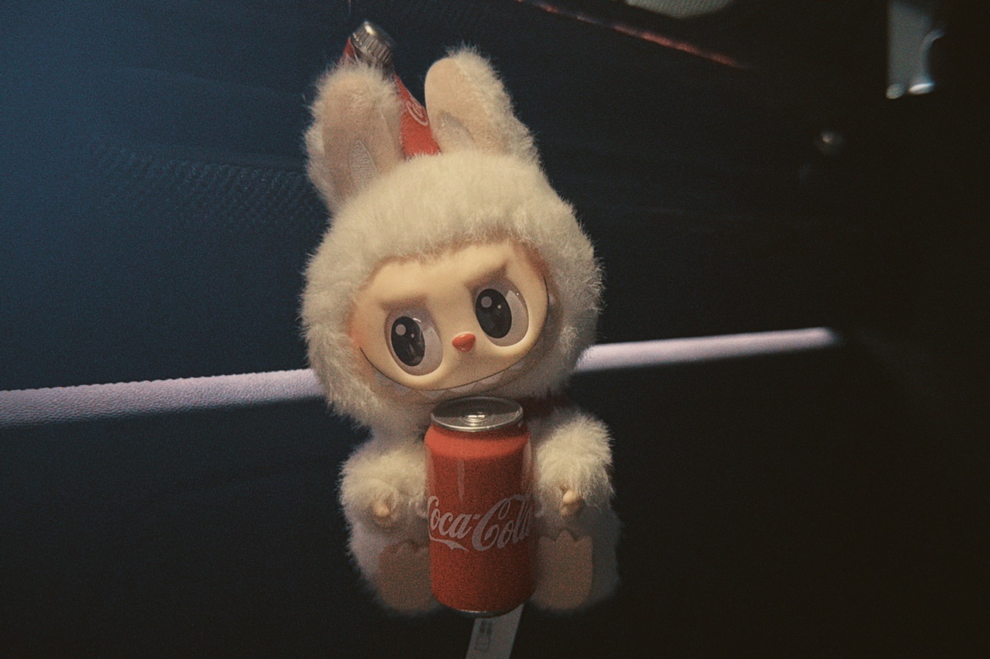 A fluffy LABUBU character holding a red Coca-Cola can