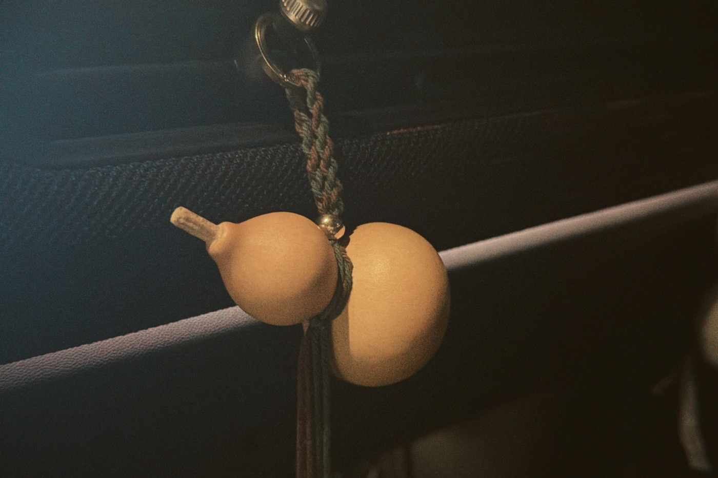 A gourd-shaped Songmont charm hanging from a cord