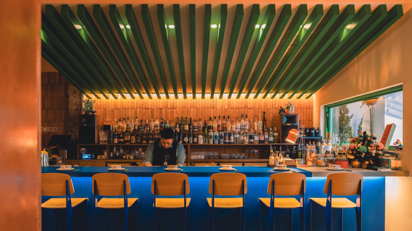 KuaTia’s blue bar counter beneath green ceiling slats