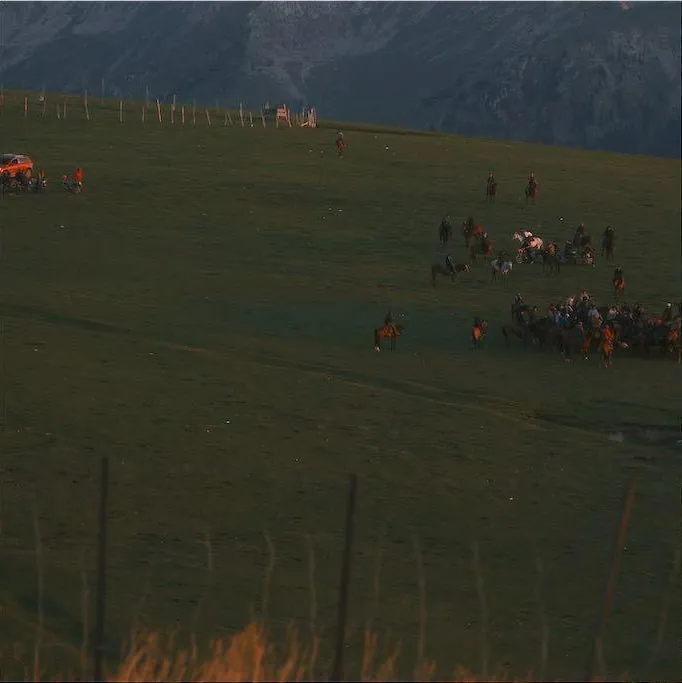 A horseback group travelling through grassland